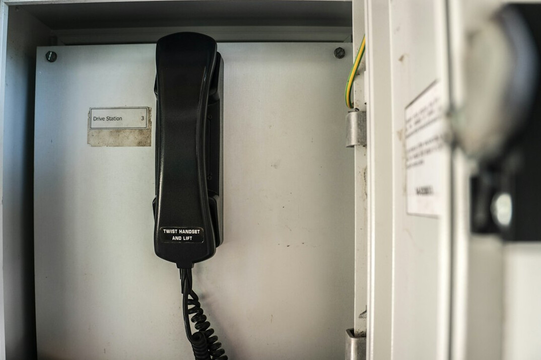 Headset hanging next to a broadcast intercom panel